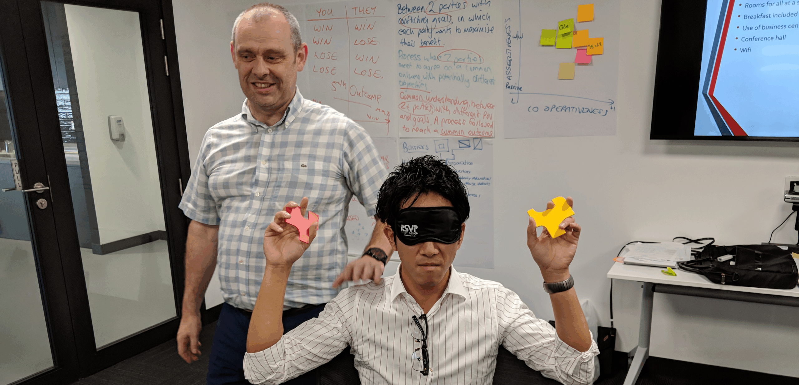 Fun learning activities for adults - a blindfolded man holds two puzzle pieces.