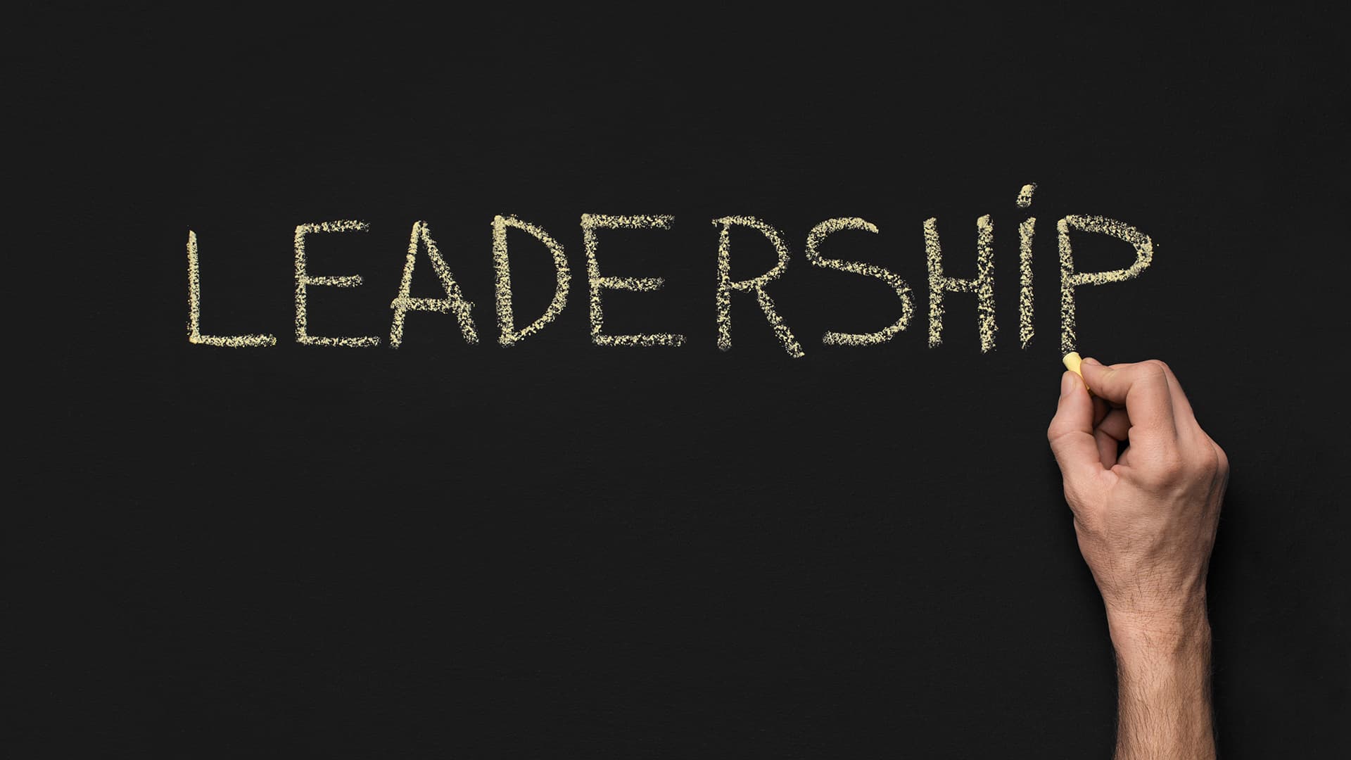 Leadership quotes. Hand writing leadership with chalk on a blackboard.