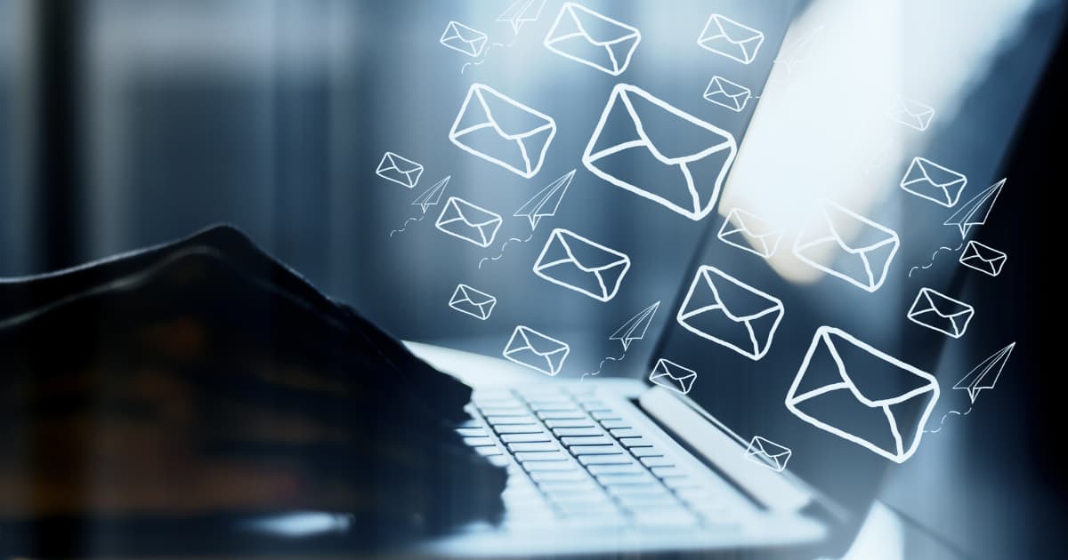 An image of a laptop with many emails being sent out along with paper planes. Email marketing mastery.